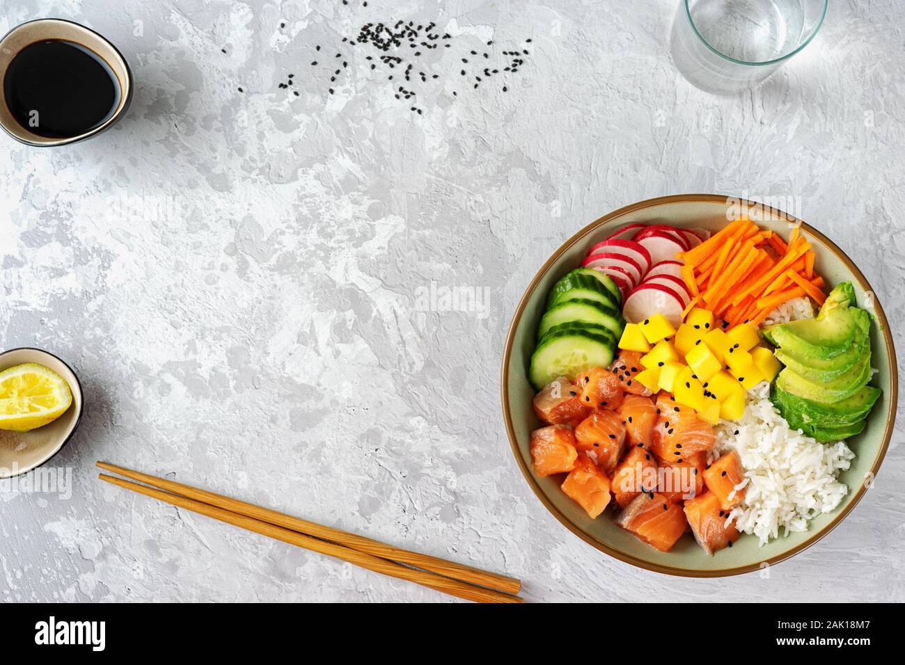 Top view of salmon poke bowl with avocado, rice, pickled carrots and ...