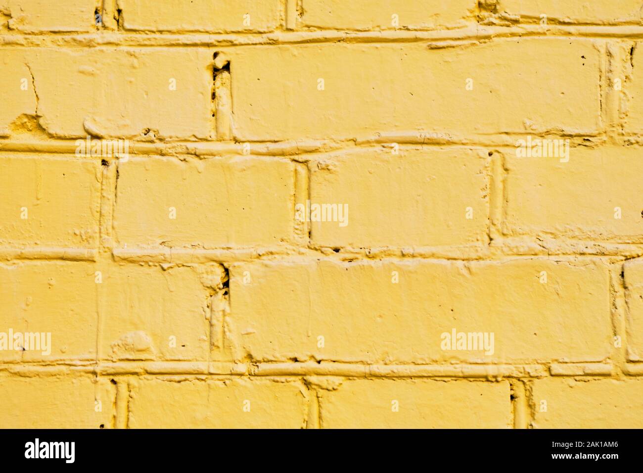 The brick wall is painted yellow. Background. Close up. Stock Photo