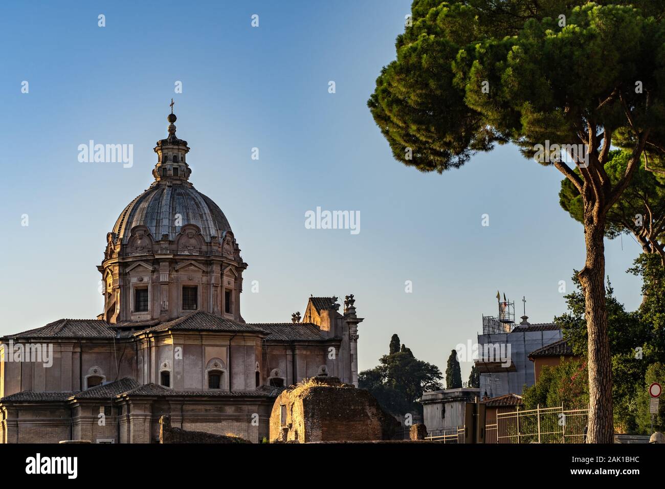 Dome of old historic catholic basilica in Rome. Green trees and dome of the church. Stock Photo