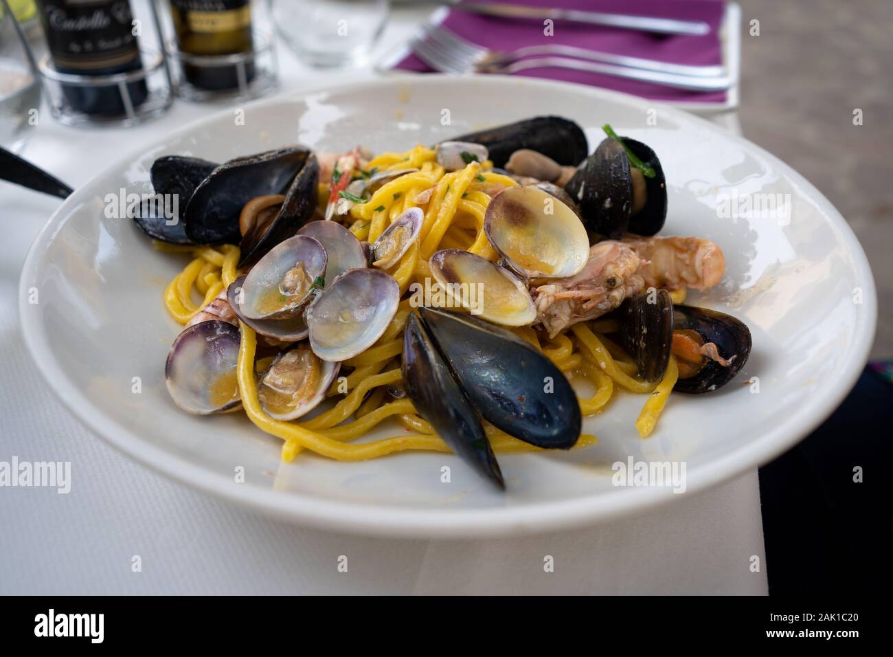 Italian pasta with seafood - mussels, vongole and shrimps. Closeup of seafood pasta served in Italian restaurant. Mediterranian cuisine. Stock Photo