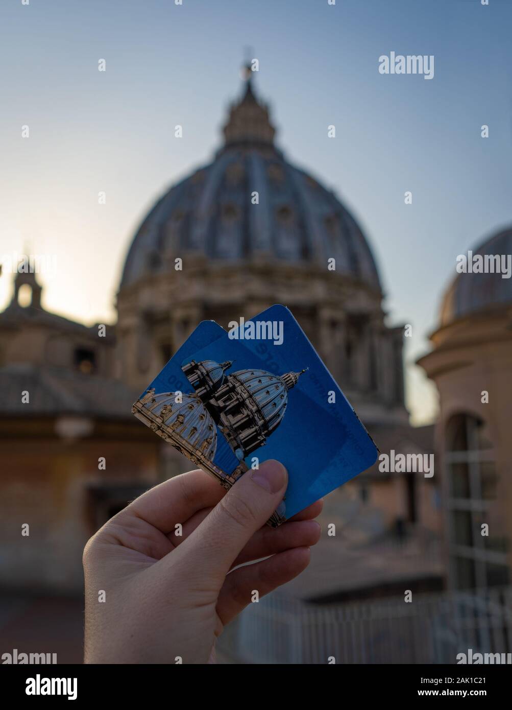 A girl is holding two tickets to the dome of Saint Peter's Basilica of Vatican in front of the dome. Focuse is on the tickets, blurred background Stock Photo