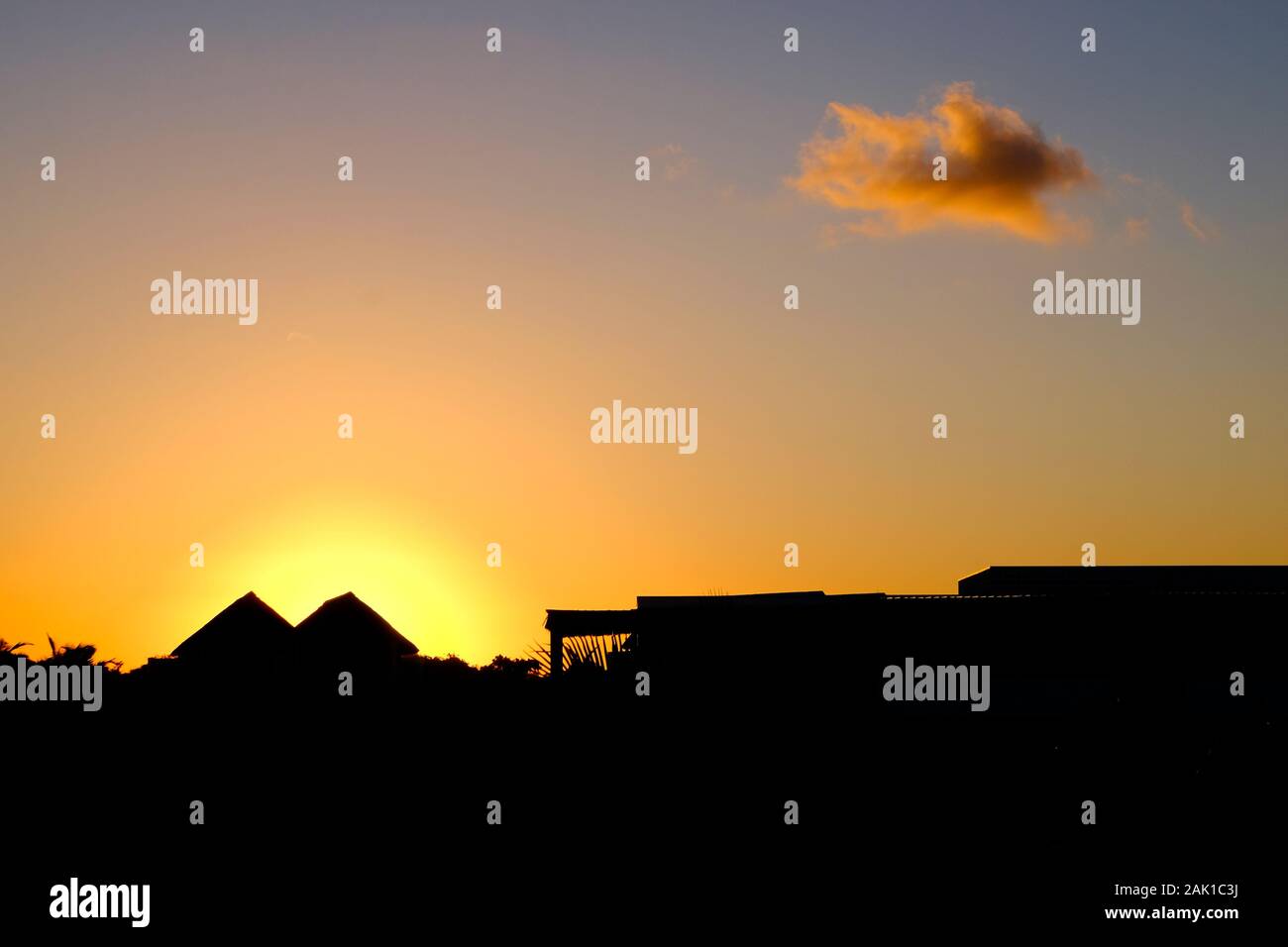 Sun setting behind a bungalow in Pemba, Mozambique Stock Photo