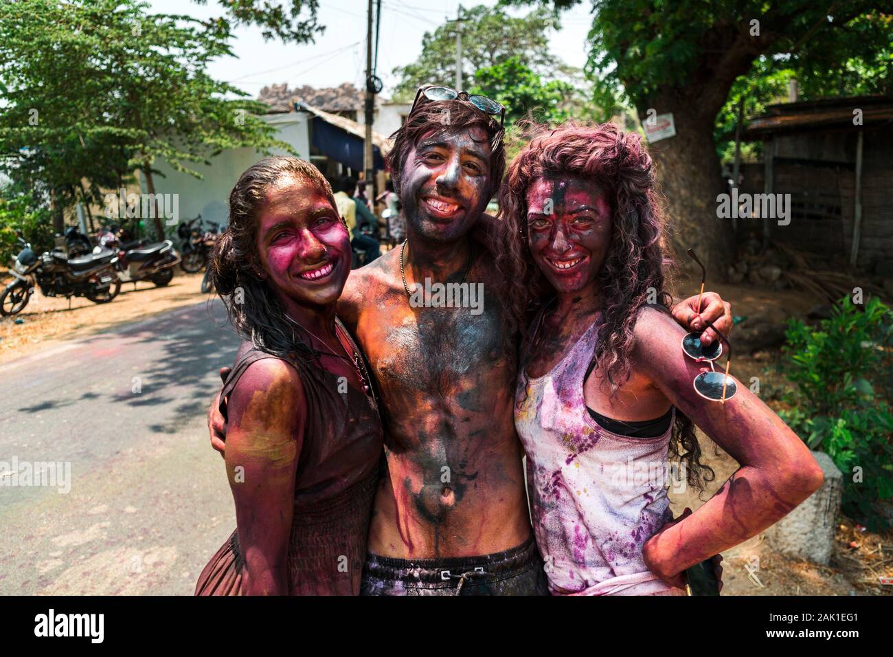 Hampi, India - April 07, 2019: happy young tourists painted in colorful pigments celebrating Holy Festival in rural village in Hanuman Halli, Karnataka, India Stock Photo