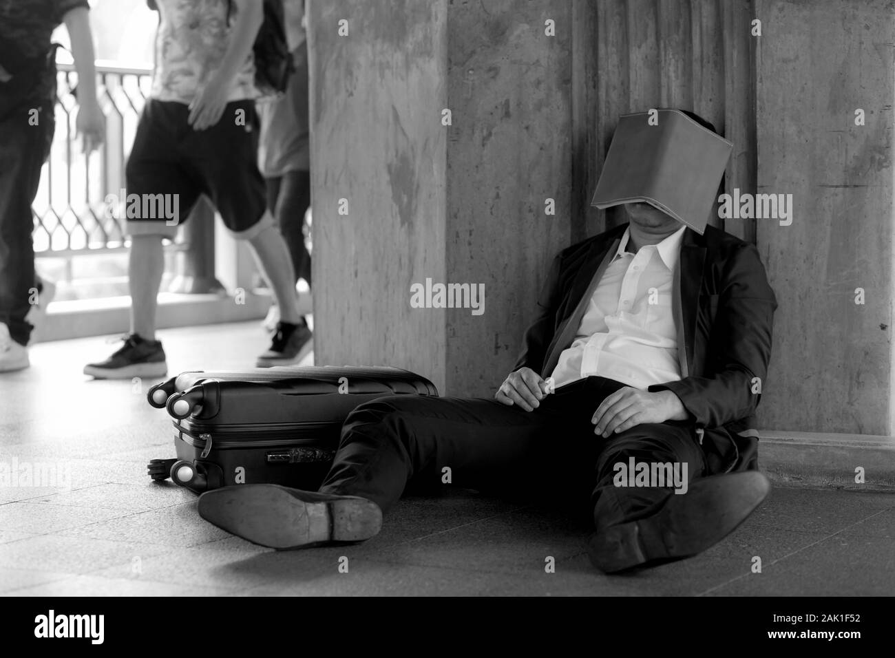 Stressed asian businessman bankrupt with sitting at outdoor and book close face. Stock Photo