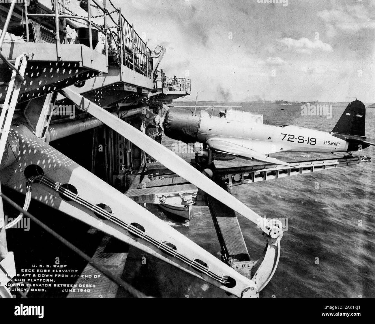 A U.S. Navy Vought SB2U-2 Vindicator (BuNo 1376) from scouting squadron VS-72 pictured on the deck edge elevator of the aircraft carrier USS Wasp (CV-7) at Quincy, Massachusetts (USA), in June 1940. The elevator consisted of a platform for the front wheels and an outrigger for the tail wheel. The two arms on the sides moved the platform in a half-circle up and down between the flight deck and the hangar deck. Stock Photo