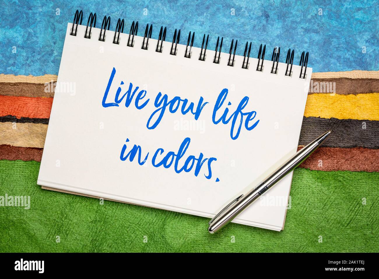 Live your life in colors inspirational quote - handwriting in a sketchbook against colorful abstract landscape. Happiness and positivity concept. Stock Photo