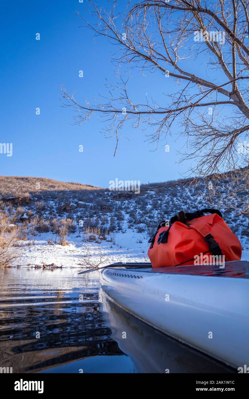 stand up paddleboard with a dry bag on a deck, winter scenery on a