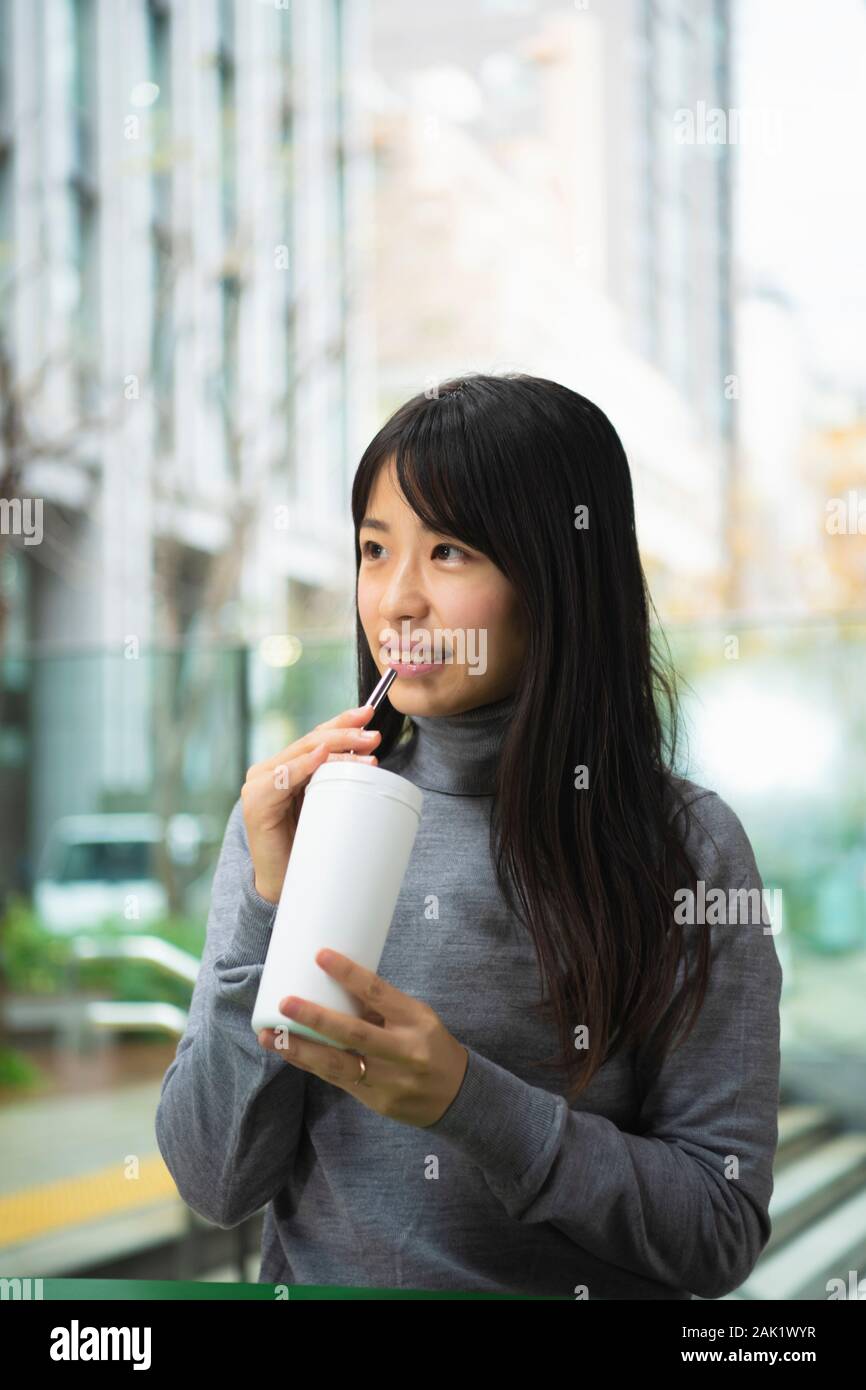 Woman drinking reusable straw Stock Photo