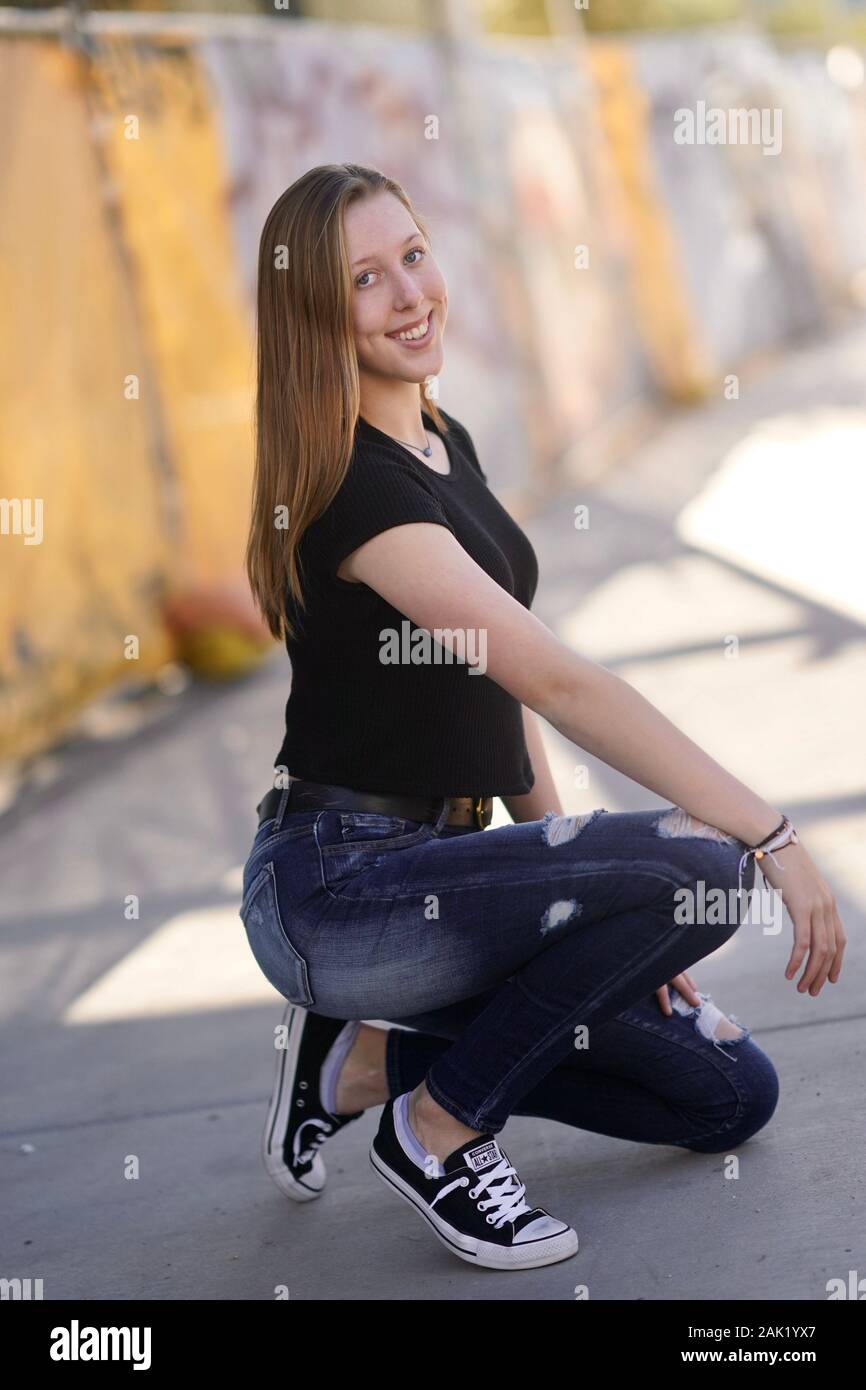 A teenage girl strikes a pose in an urban setting. Stock Photo