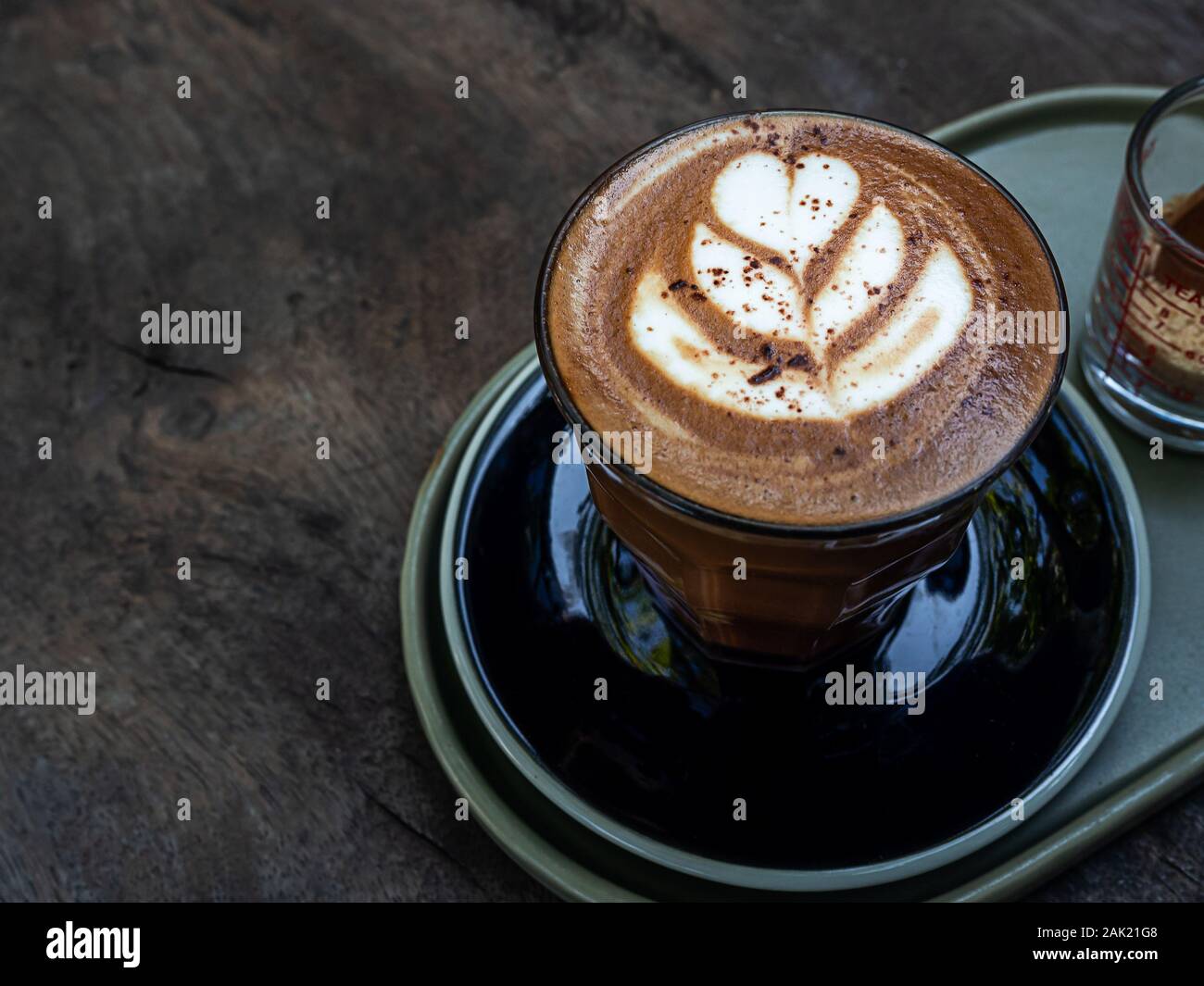 https://c8.alamy.com/comp/2AK21G8/mocha-coffee-with-latte-art-in-glass-on-wooden-table-background-minimal-style-2AK21G8.jpg