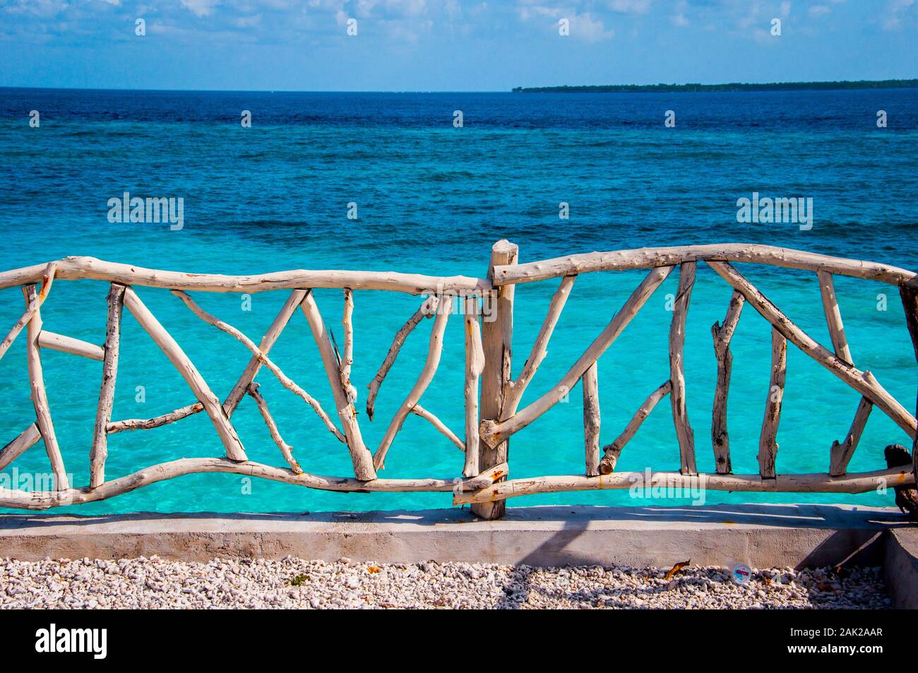 White painted wooden fence facing the blue sea in Bira Beach, South Sulawesi. Stock Photo