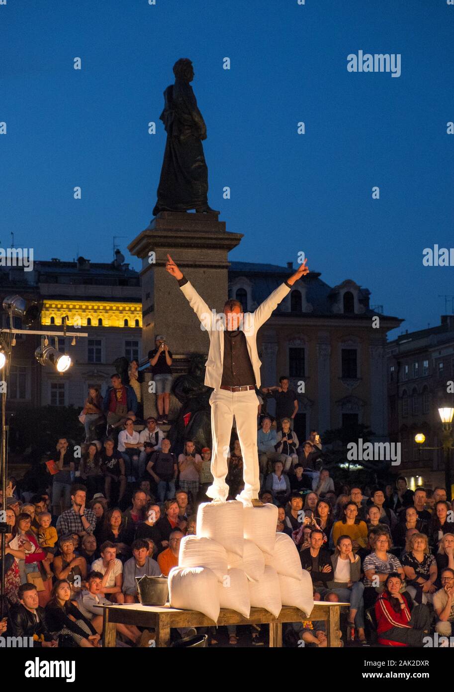 A street performer performs an act in front of a crowd in the main square, Krakow, Poland Stock Photo