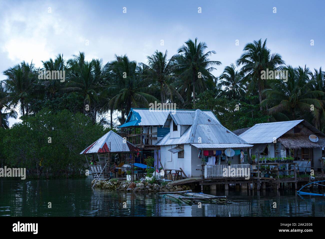 Basic homes on stilts above water in local village Stock Photo