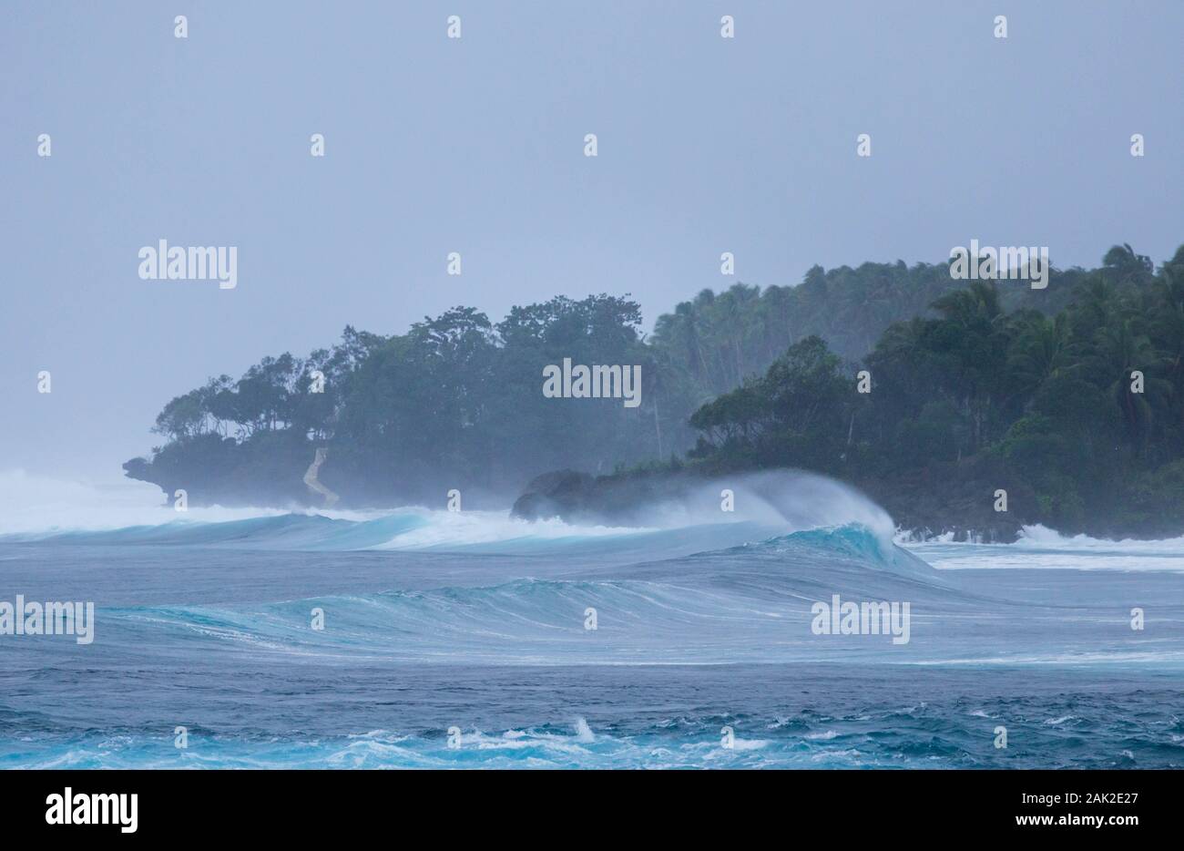 Wind whipped spray off wave in stormy coastal conditions Stock Photo