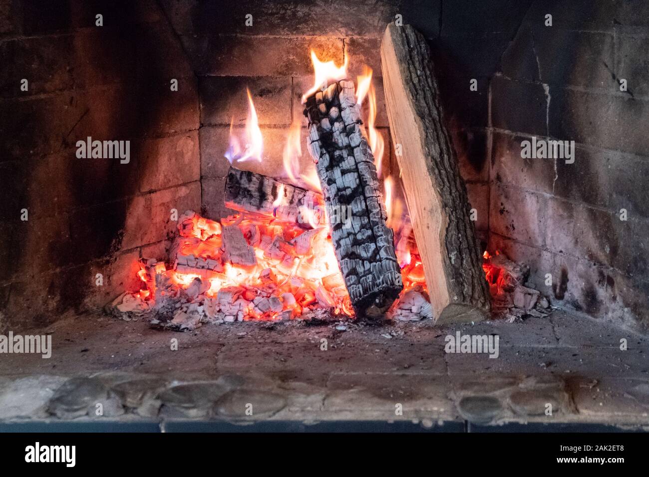 Flames in the fireplace. Burning wood. Brick fireplace Stock Photo