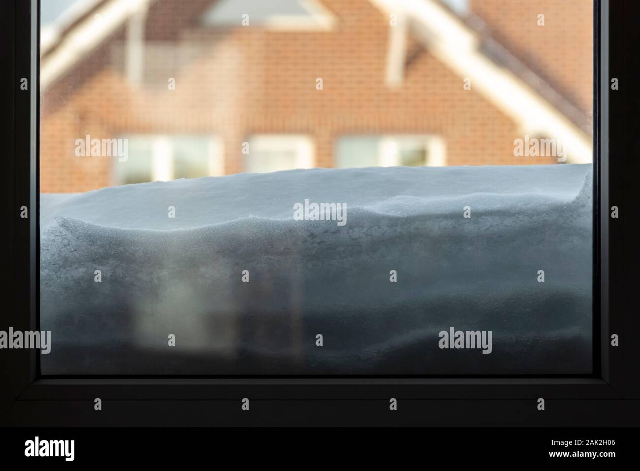 A thick layer of snow lies outside the window. Stock Photo