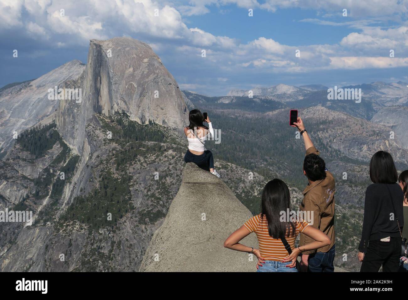 Friends taking selfies and travel photos at Half Dome viewpoint, California Stock Photo
