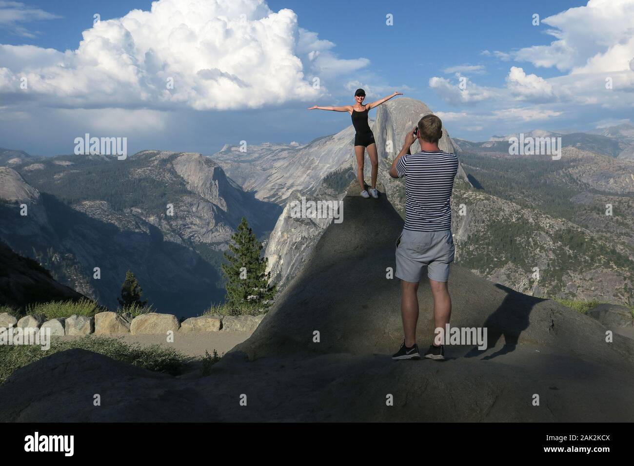 European Travel Couple Taking Daredevil Photos With Half Dome - Yosemite National Park Stock Photo