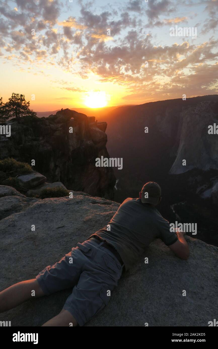 Daredevil Hiker Man on Edge of Taft Point, Yosemite Sunset Stock Photo