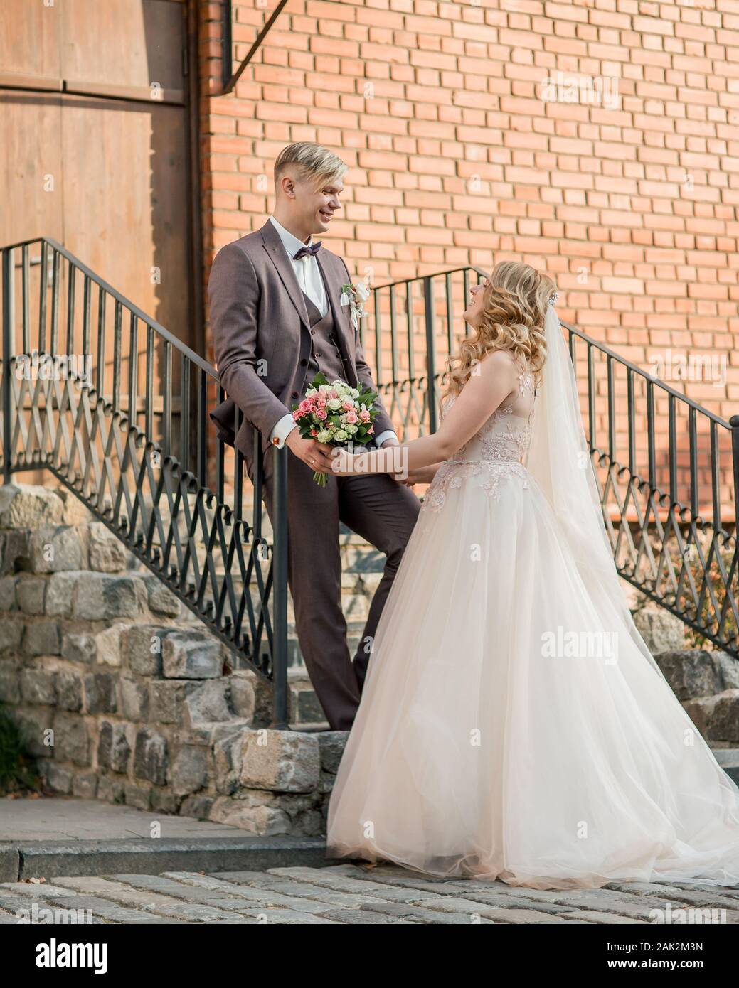 bride and groom standing on the porch of a brick house Stock Photo - Alamy