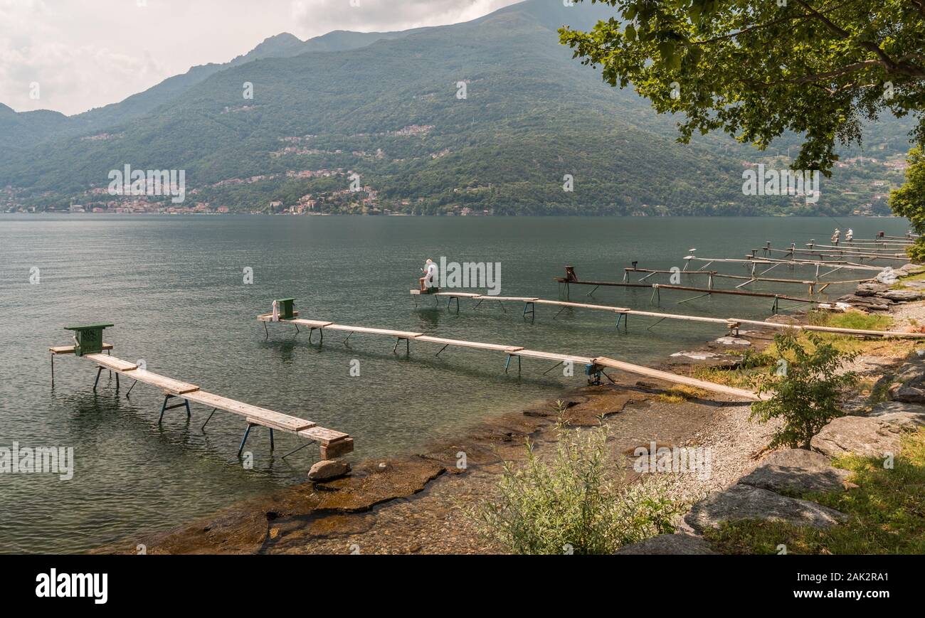 A scene of Lake Como with people fishing on the lakeside in the mid and background Stock Photo