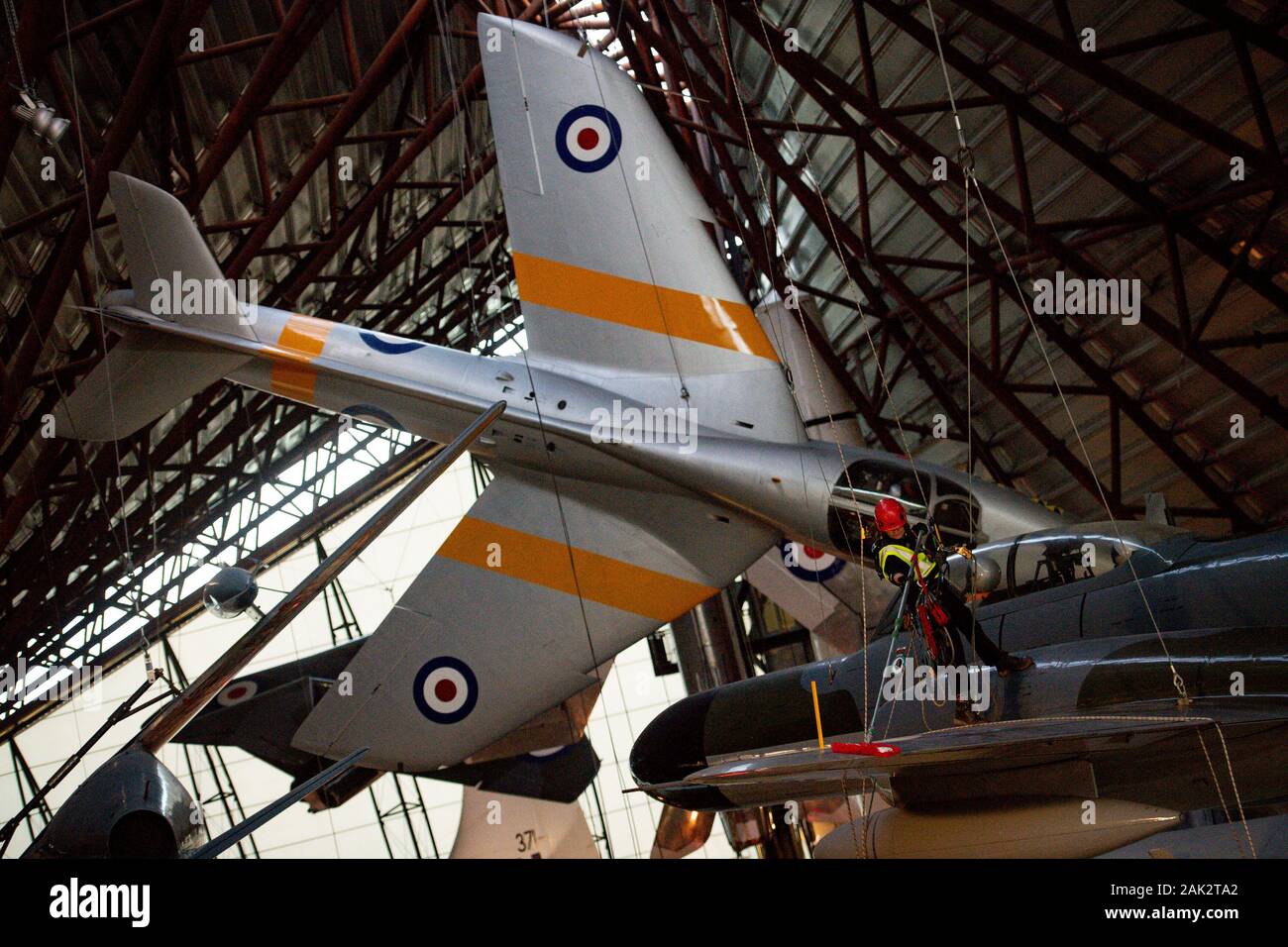 Specialist operators at the Royal Air Force Museum Cosford, near Telford, Shropshire, clean the suspended Armstrong Whitworth Meteor NF14 aircraft displayed within the museum's National Cold War Exhibition, during the annual high-level aircraft cleaning and maintenance. Stock Photo