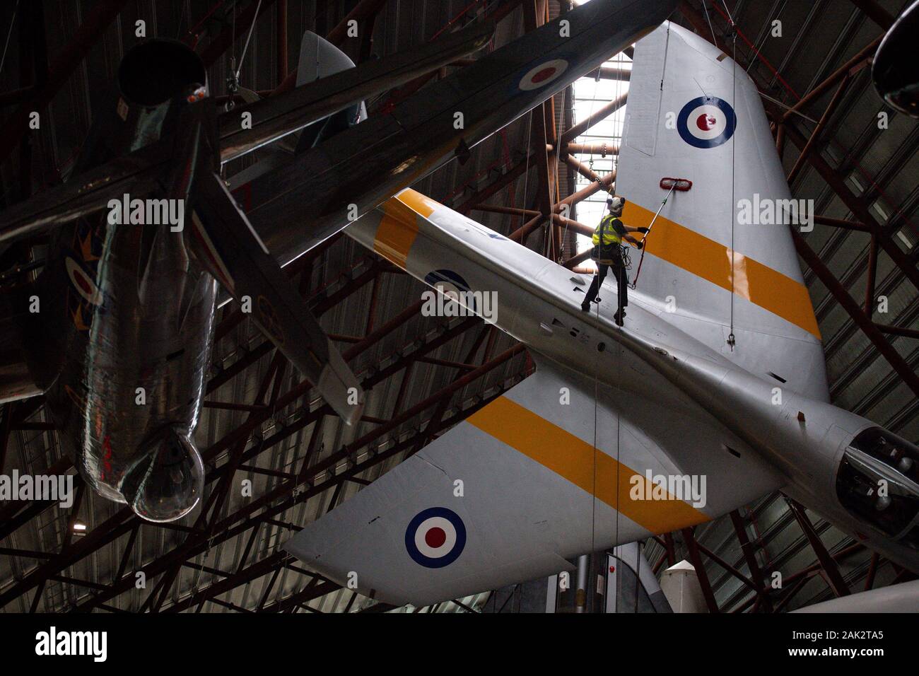 Specialist operators at the Royal Air Force Museum Cosford, near Telford, Shropshire, clean the suspended Hawker Hunter aircraft displayed within the museum's National Cold War Exhibition, during the annual high-level aircraft cleaning and maintenance. Stock Photo
