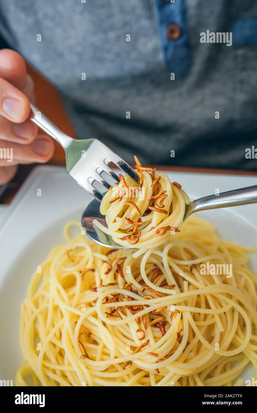 Hands of man eating spaghetti with worms Stock Photo Alamy