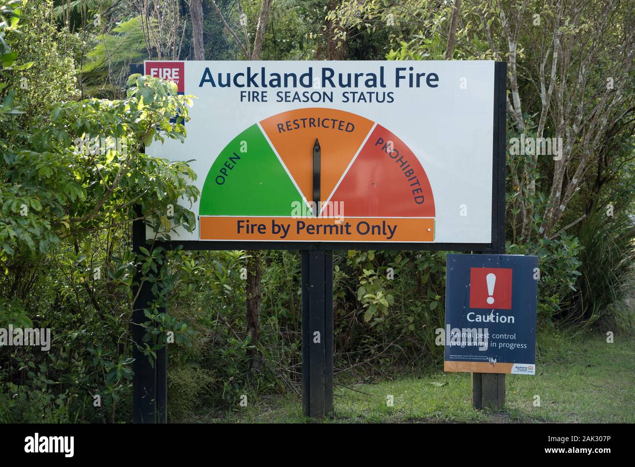 Auckland Rural Fire season status warning sign native bush roadside, permit only restricted, Piha, Waitakere Ranges, West Coast, pest control caution Stock Photo