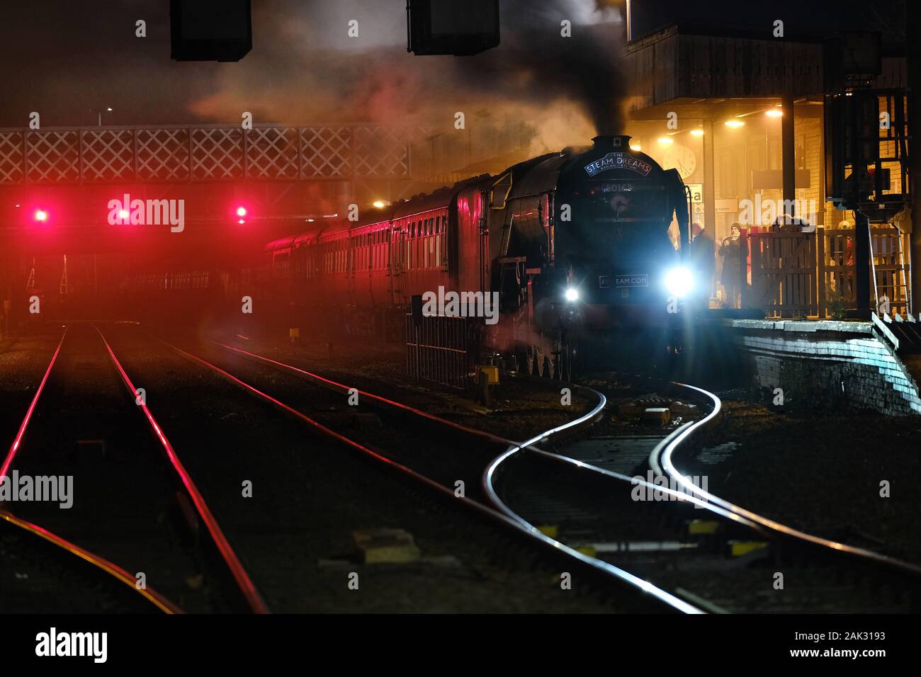 Modern replica steam engine in Lincoln station at night with enthusiast train. Stock Photo