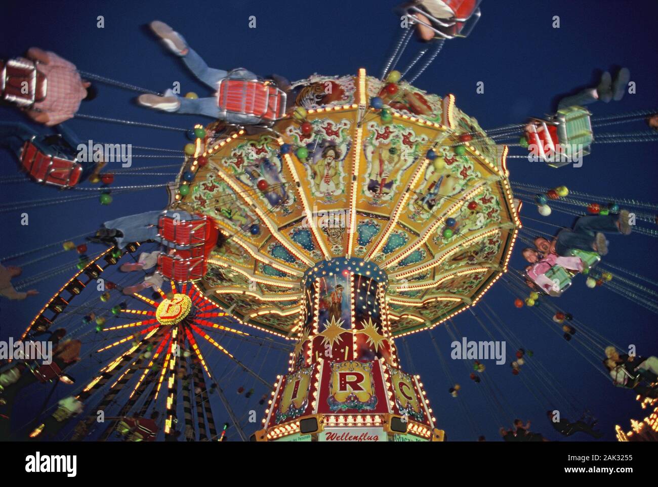 An illuminated chairoplane is spinning round in the dawn at the anually Cranger fair in the city Herne, North Rhine-Westphalia, Germany. (Undated pict Stock Photo
