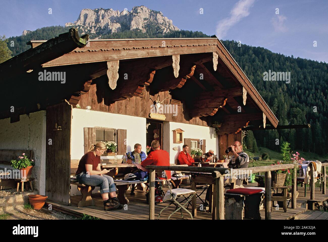 Hikers sitting on the terrace of the Dandl Alp on the Roethelmoos highmoor, a hiking destination in the region of the Rauschberg mountain in the Chiem Stock Photo