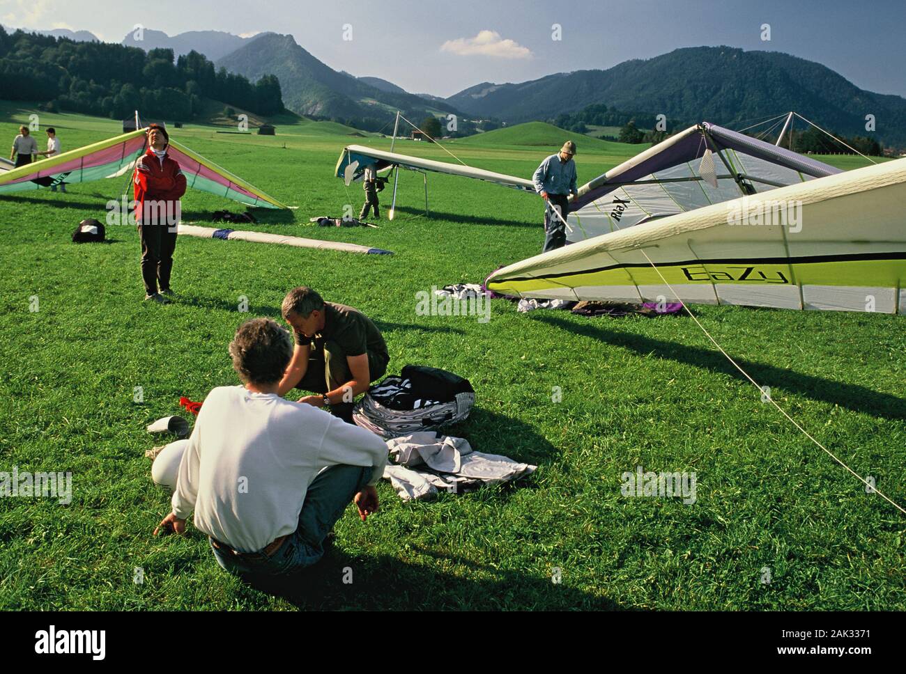 Hang gliders preparing their kites at the Rauschberg mountain near Ruhpolding in the Upper