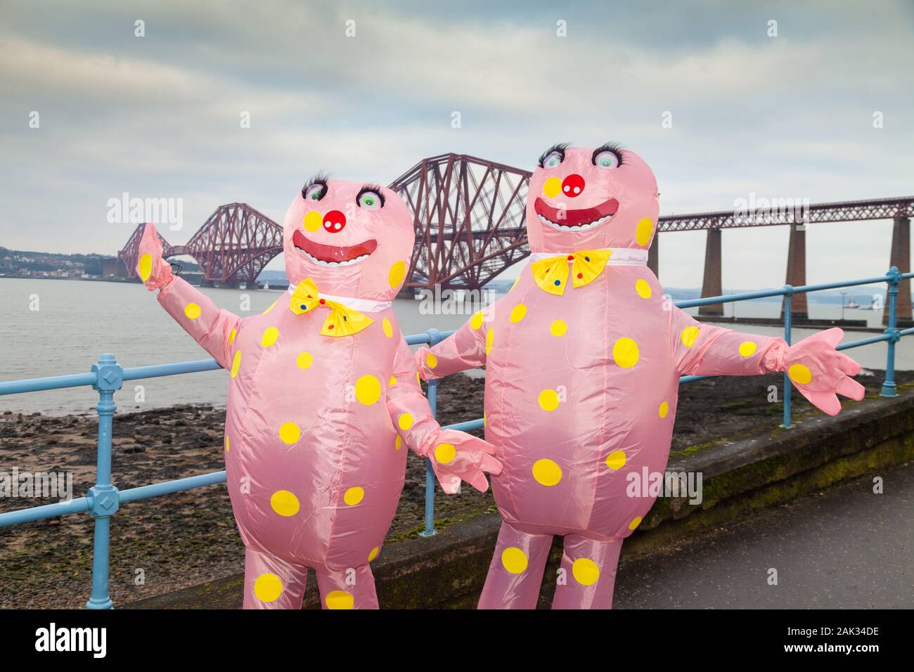 Revellers wearing fancy dress for the Traditional New Years Day Loony Dook with the Iconic Forth Bridge in the Background Stock Photo