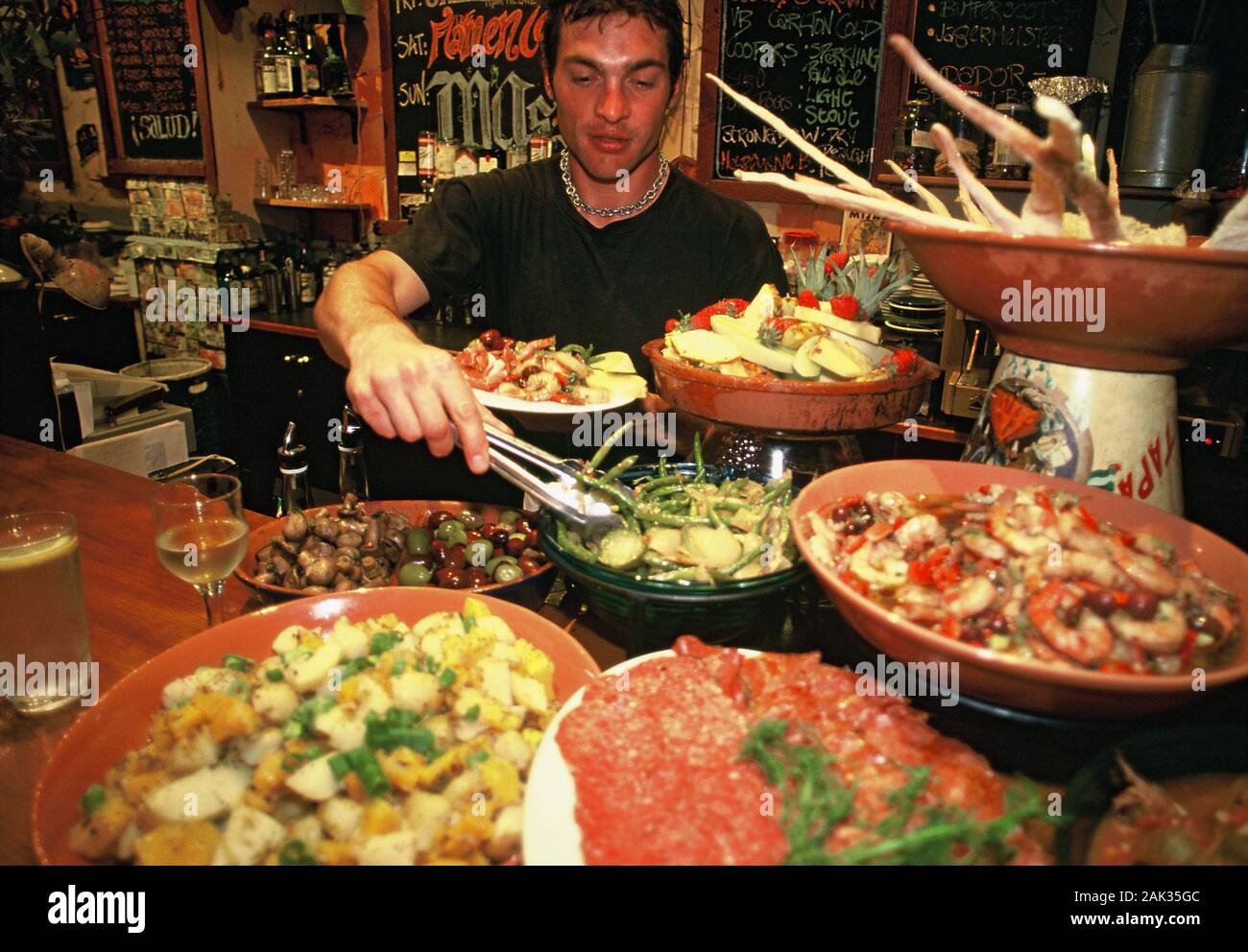 Spanish Rundel A man serves himself Spanish starters called Tapas, in the bar Tapas in ...