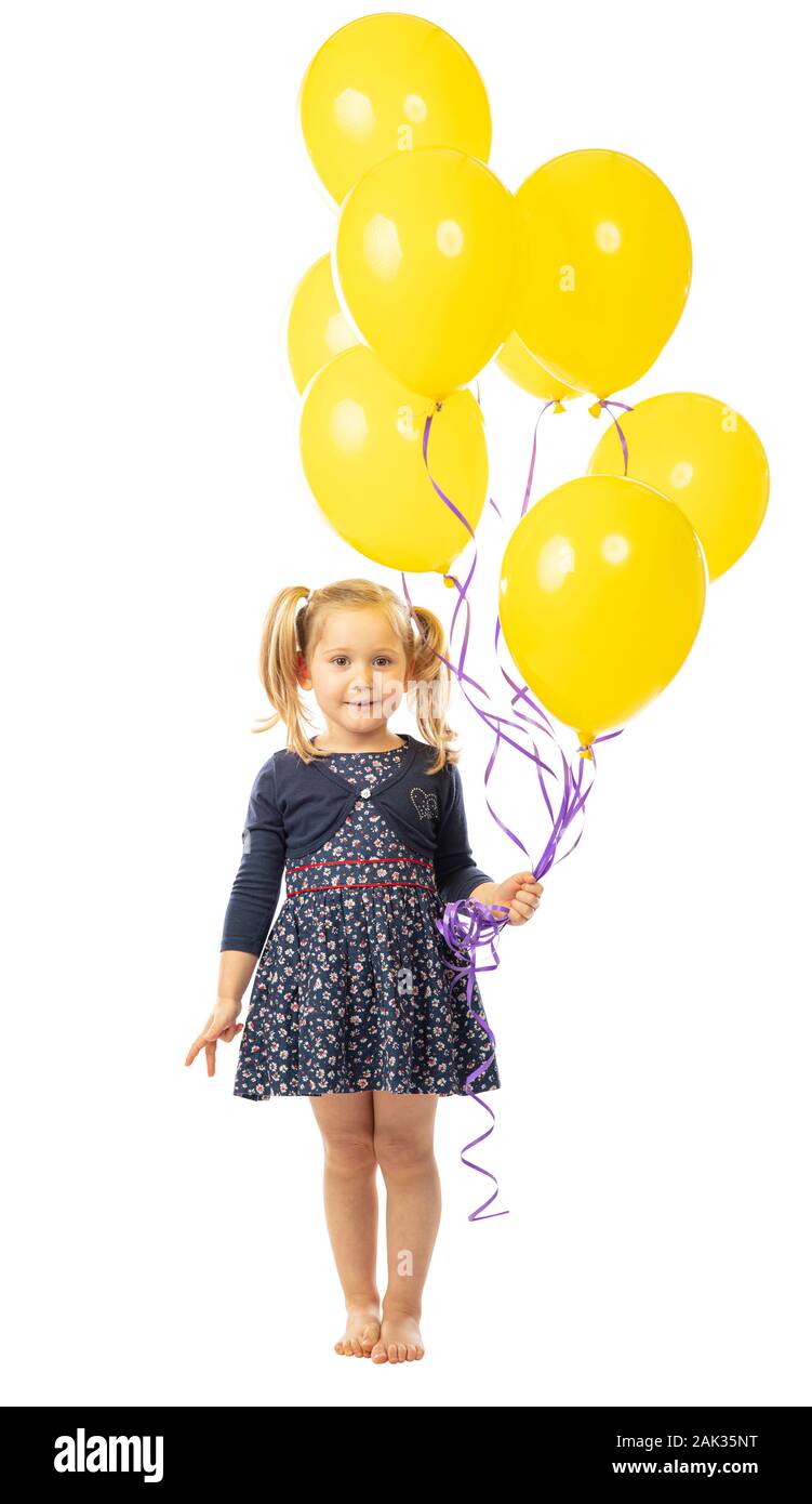 portrait of a smiling blonde 3 year old girl holding a group of yellow balloons. isolated on white Stock Photo