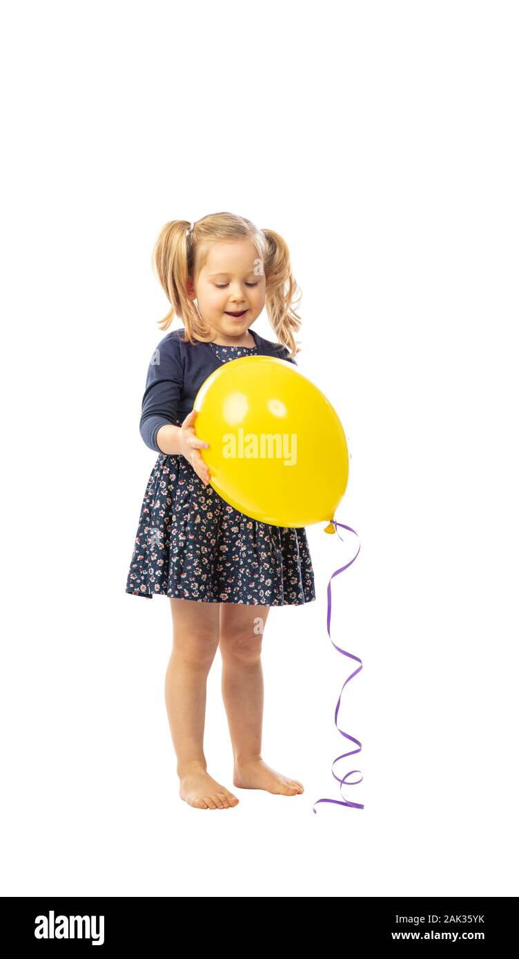 standing little girl holds a yellow balloon, happy and satisfied expression. isolated on white background. Stock Photo