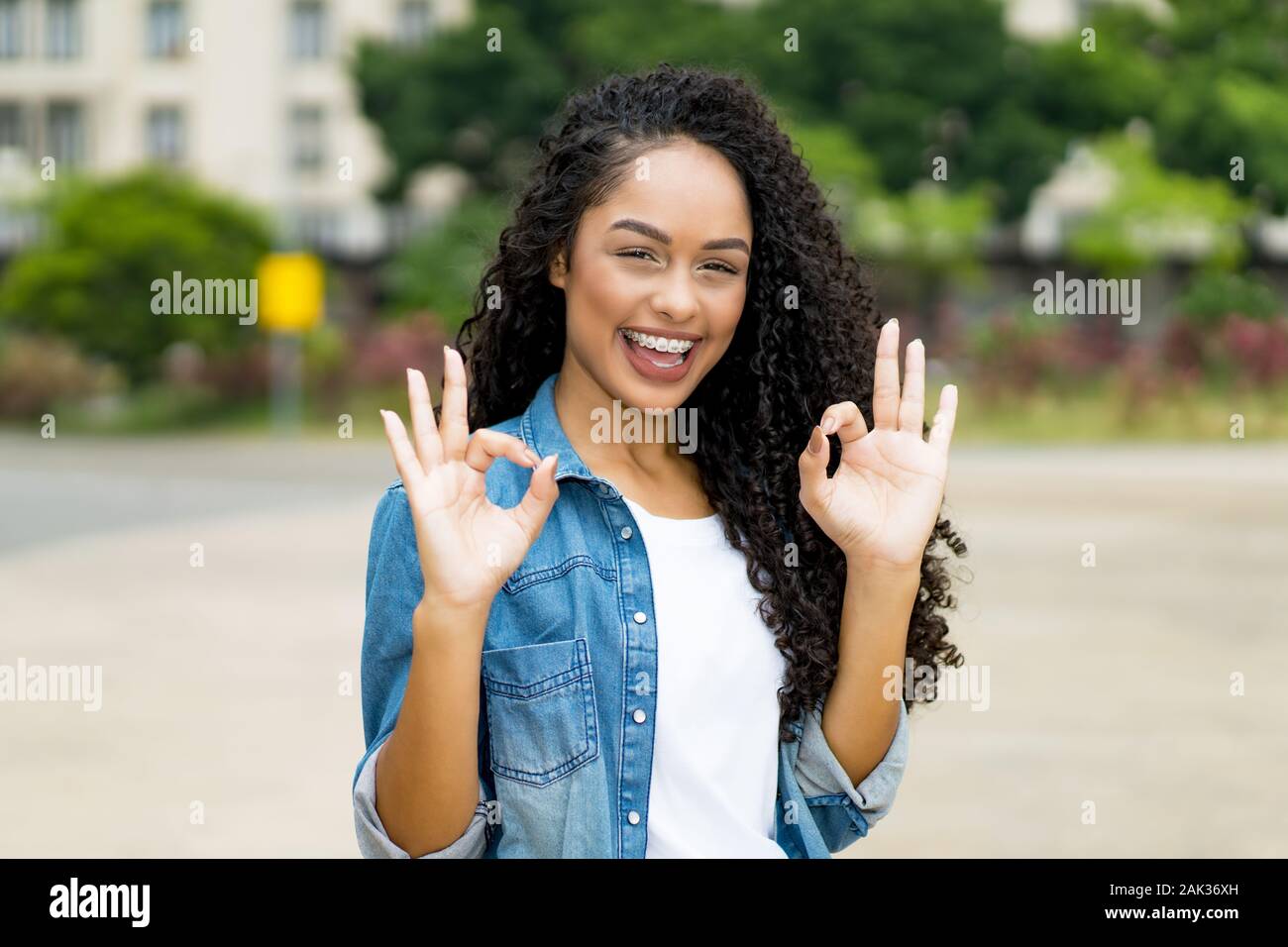 Happy Brazilian Girl With Curly Hair And Braces Outdoor In Summer
