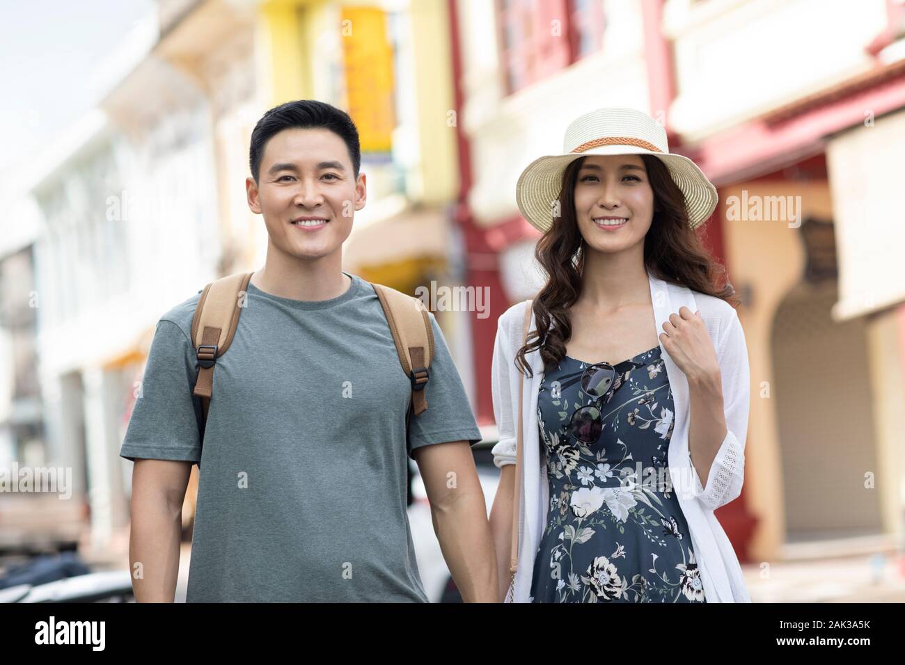 Happy young Chinese couple holding hands on street Stock Photo - Alamy