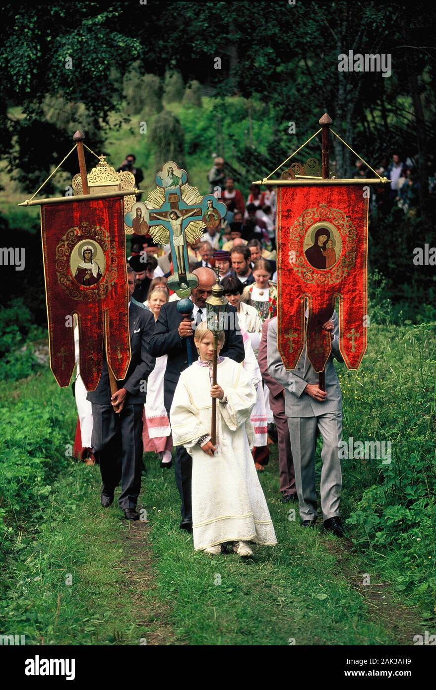 Orthodox christian carrying flags and crosses during the procession of the Church anniversary in Ilomantsi. Ilomantsi is situated in North Karelia in Stock Photo
