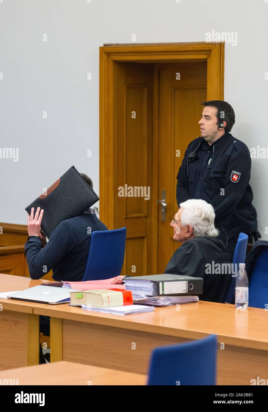 07 January 2020, Lower Saxony, Lüneburg: The defendant (l) sits next to Herbert Lederer (r), his lawyer, in the Lüneburg Regional Court before the start of the trial. The 26-year-old is alleged to have sexually abused several children in Lueneburg and other places as trainer and supervisor of a DLRG local group. Photo: Philipp Schulze/dpa Stock Photo