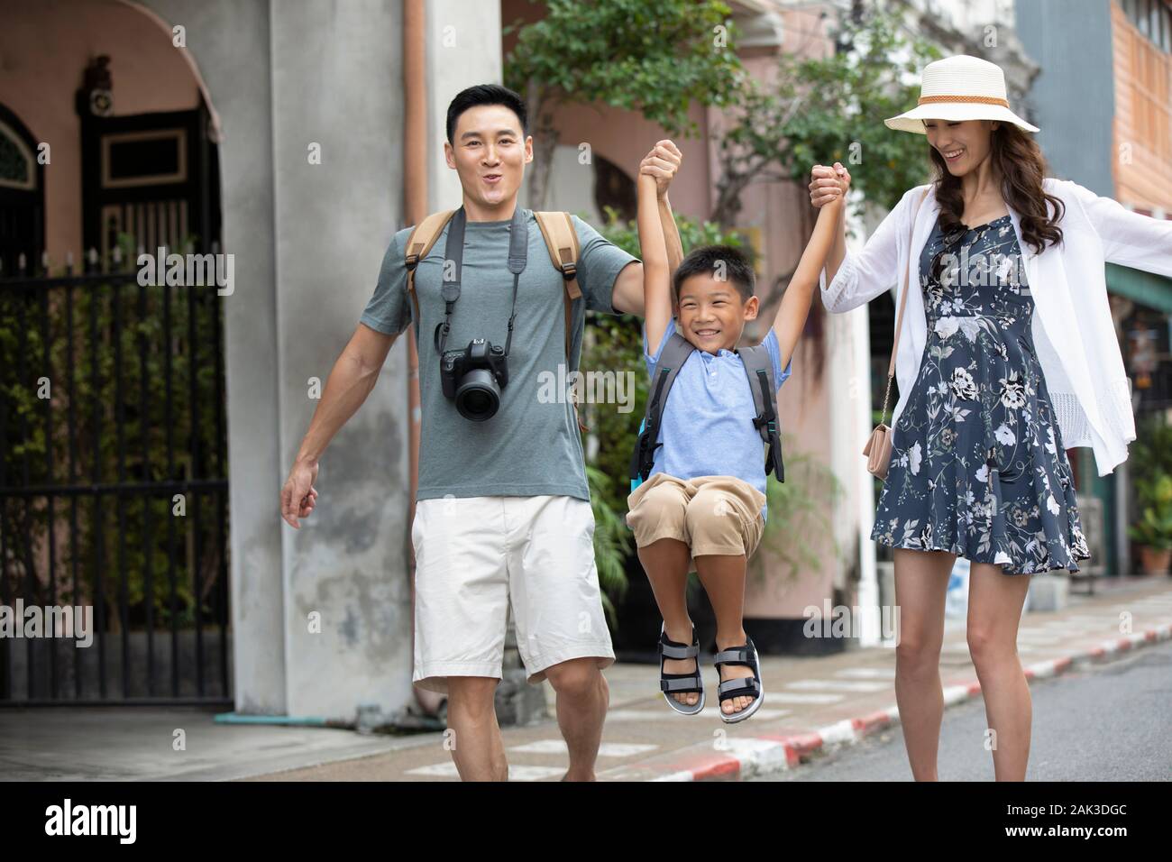 Happy young Chinese family walking on street Stock Photo - Alamy