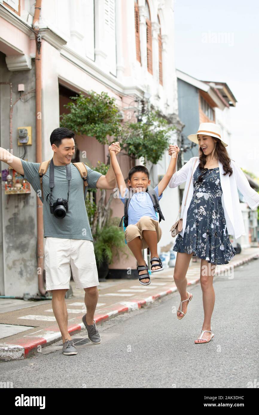 Happy young Chinese family walking on street Stock Photo - Alamy