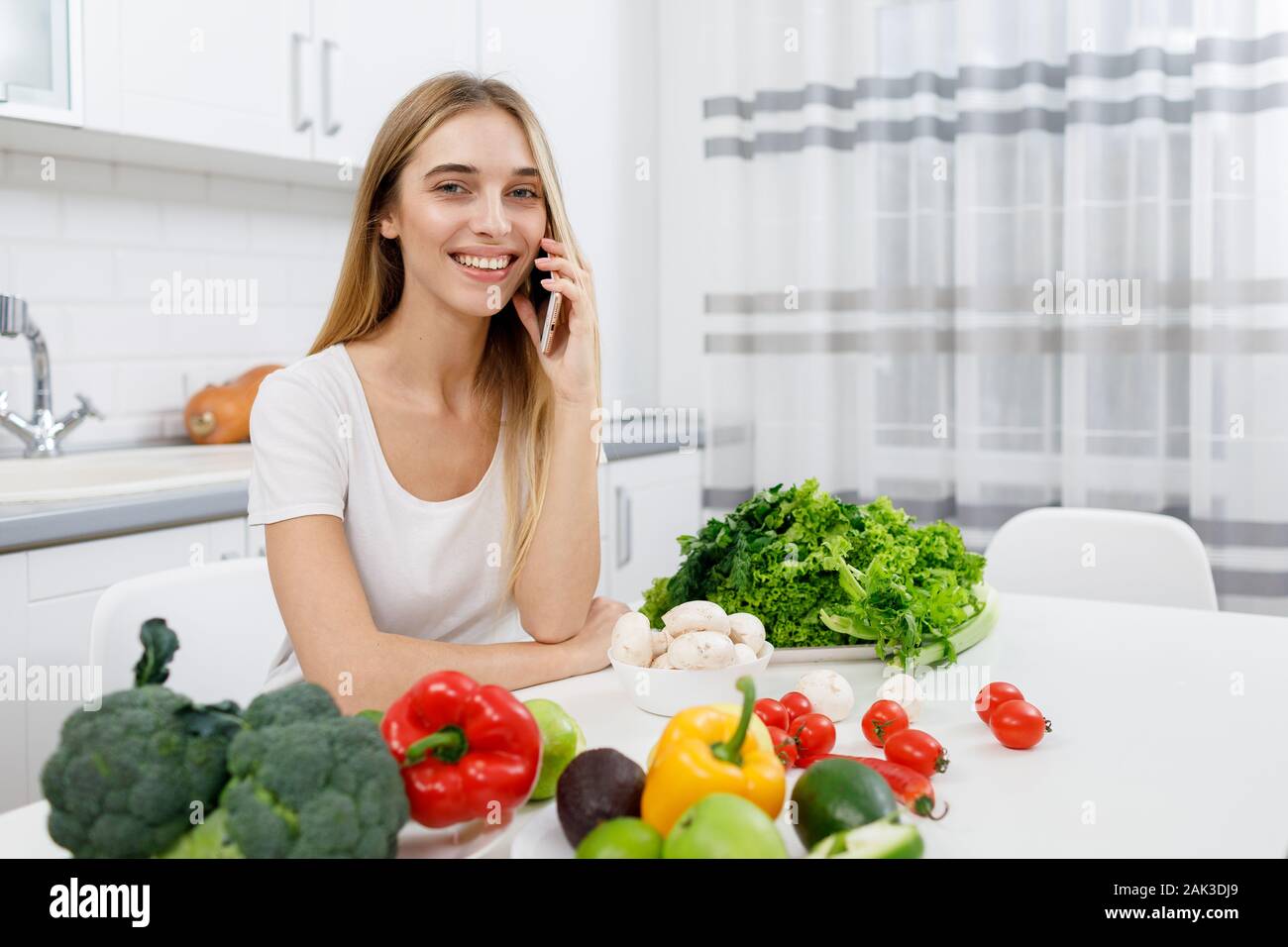 Young Housewife Exchanging Cooking Recipes via Smartphone Stock Photo