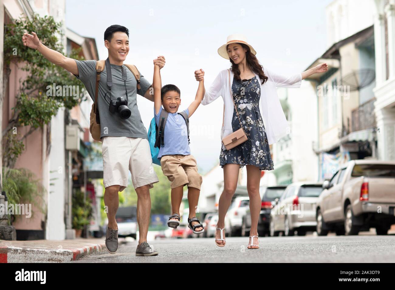 Happy young Chinese family walking on street Stock Photo - Alamy