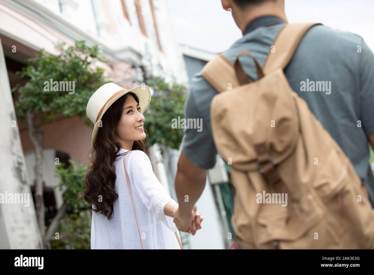 Happy young Chinese couple holding hands on street Stock Photo - Alamy