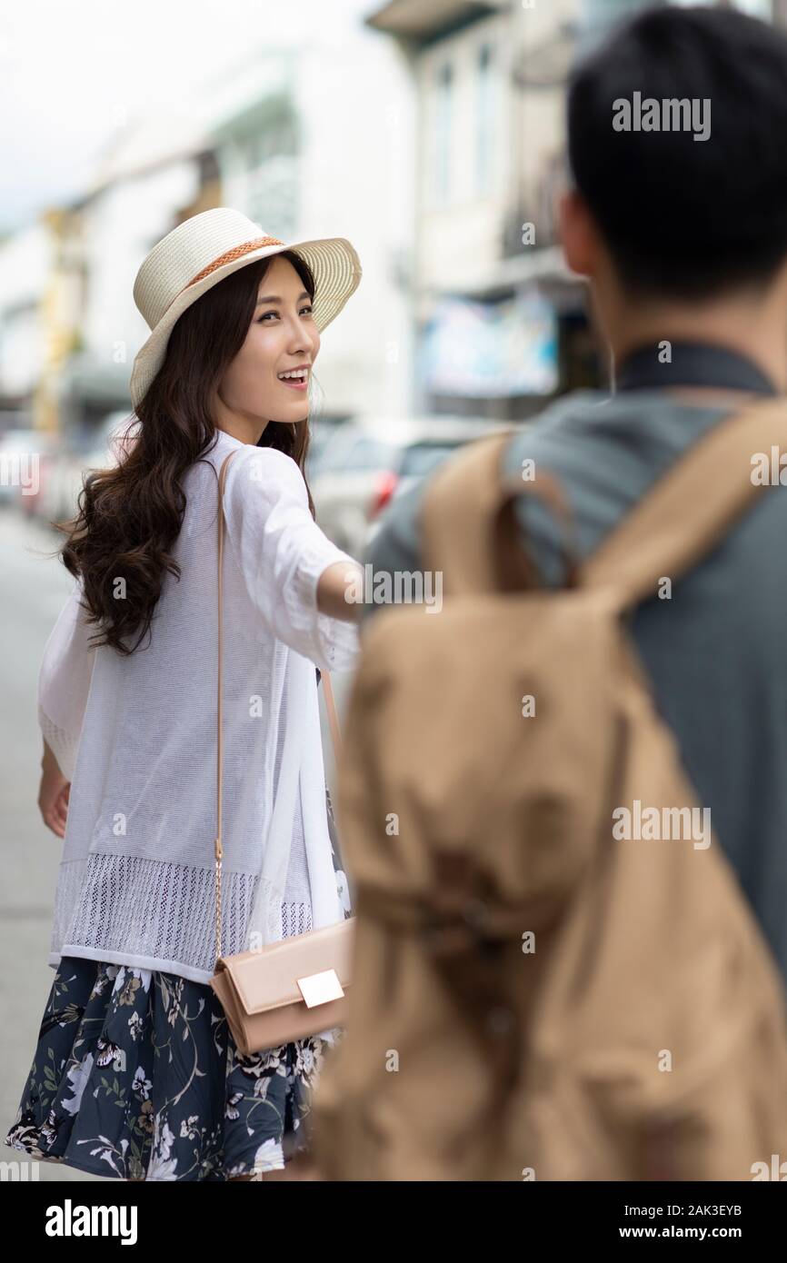 Happy young Chinese couple holding hands on street Stock Photo - Alamy