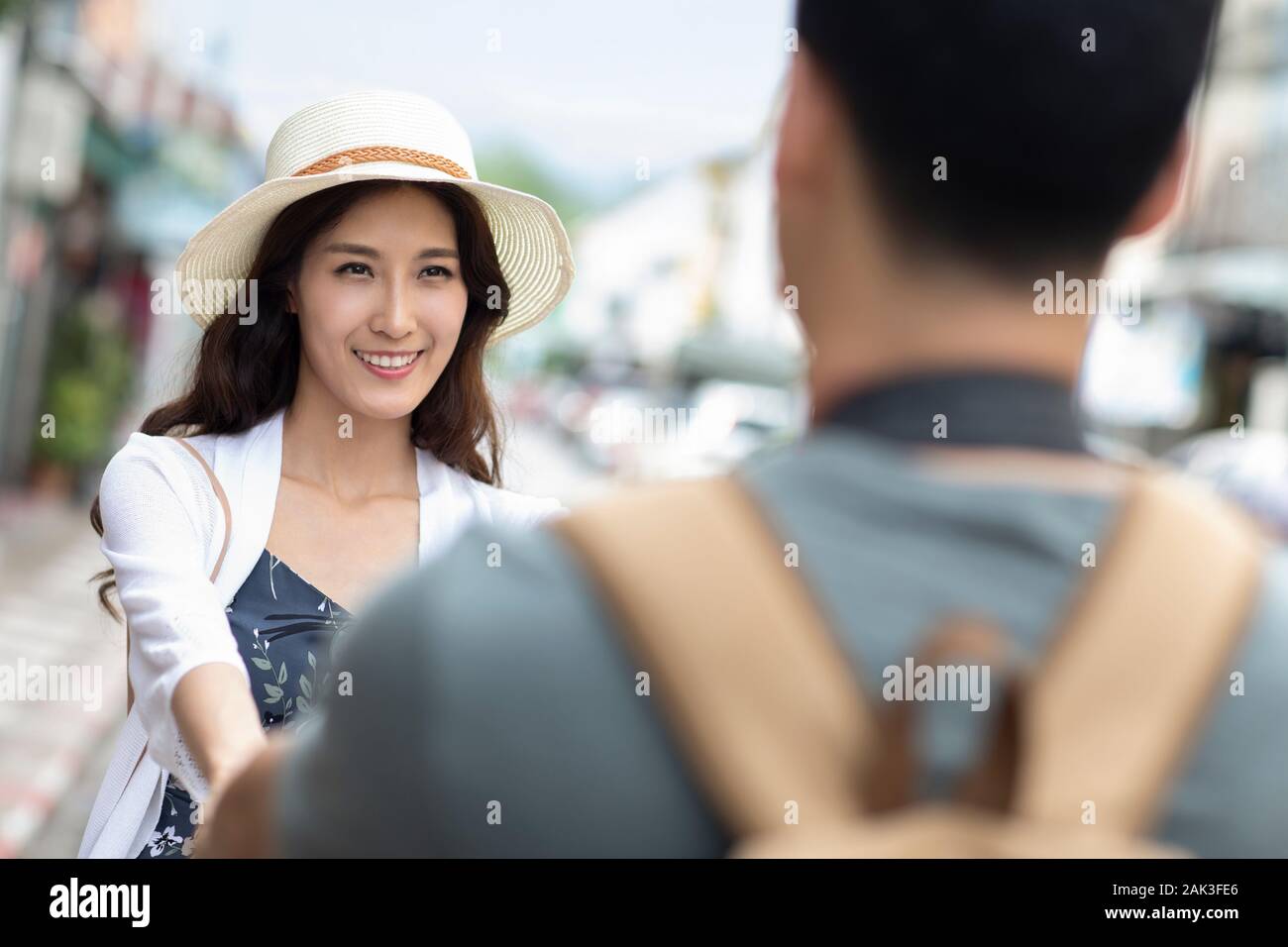Happy young Chinese couple holding hands on street Stock Photo - Alamy