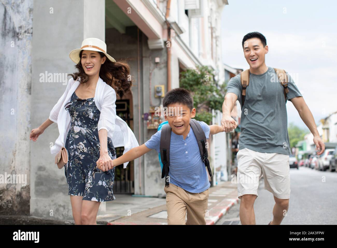 Happy young Chinese family running on street Stock Photo - Alamy