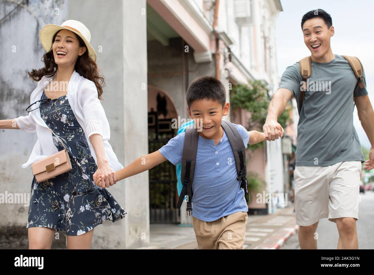 Happy young Chinese family running on street Stock Photo - Alamy